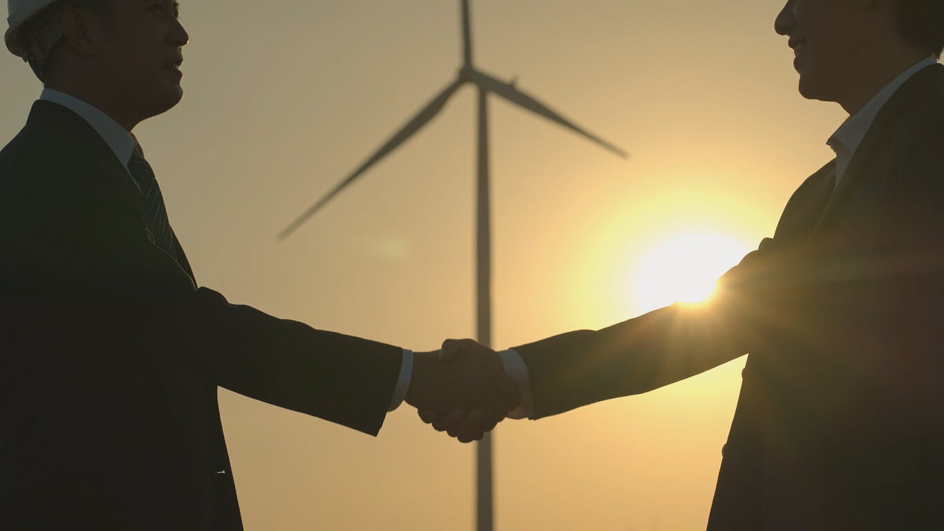Close-up de empresários e engenheiros de terno preto fechando negócio de energia renovável