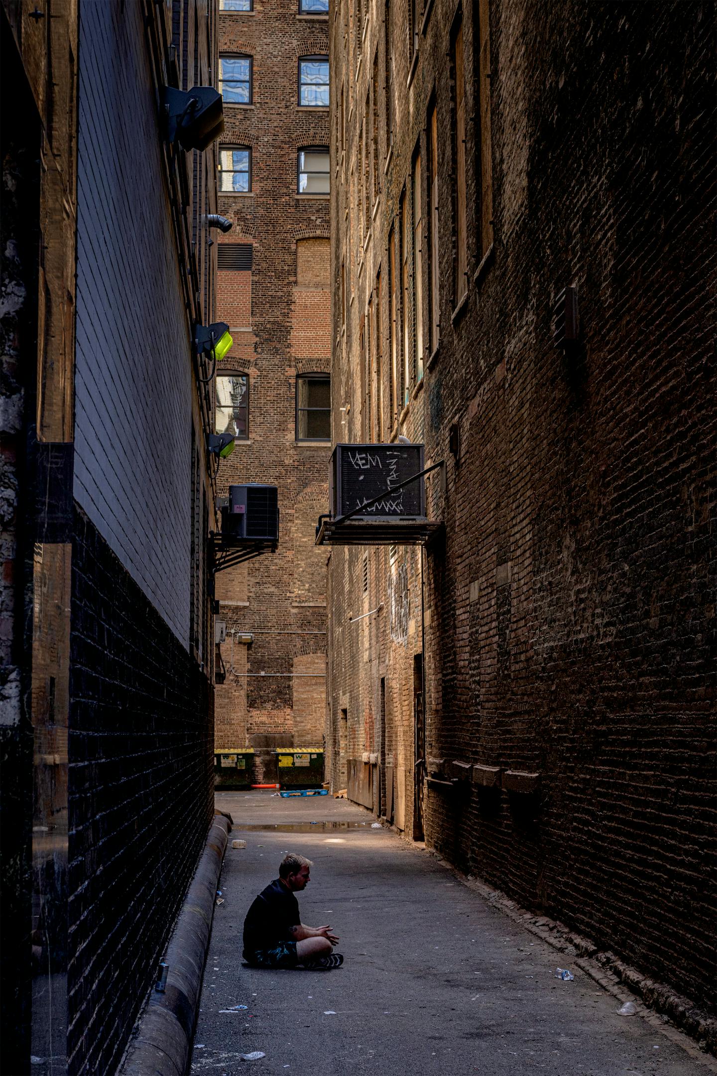 Ein Mann sitzt in einer heruntergekommenen Gasse in Chicago.