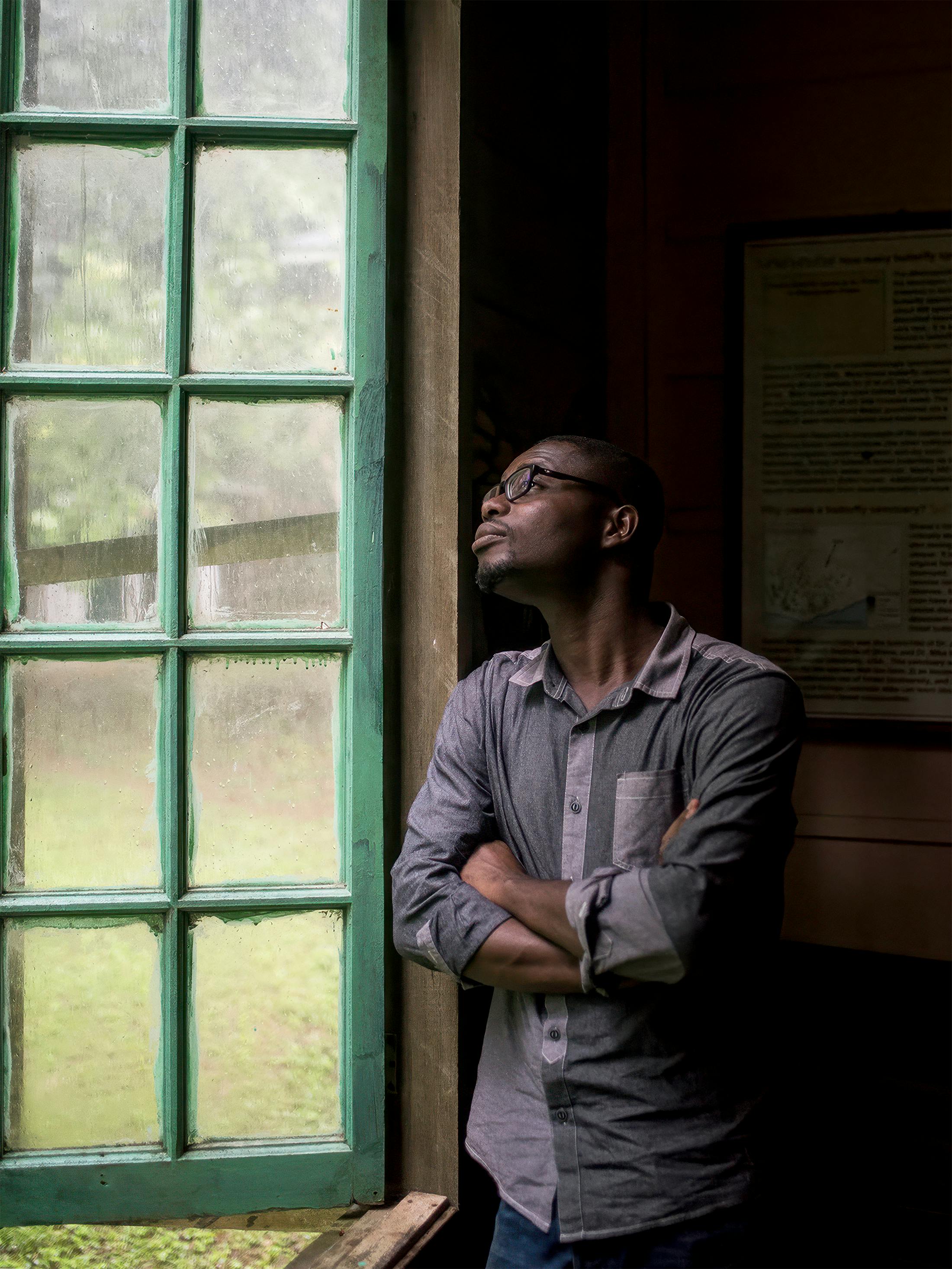 Edmund Ekuadzi blickt aus dem Laborfenster auf die regnerische Natur in Ghana.