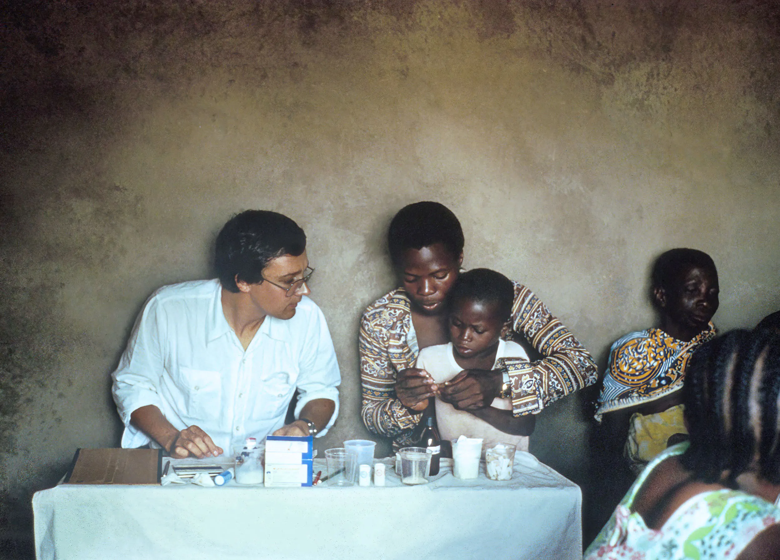Marcel Tanner zeigt einem jungen Vater und seinem Kind Medikamente.