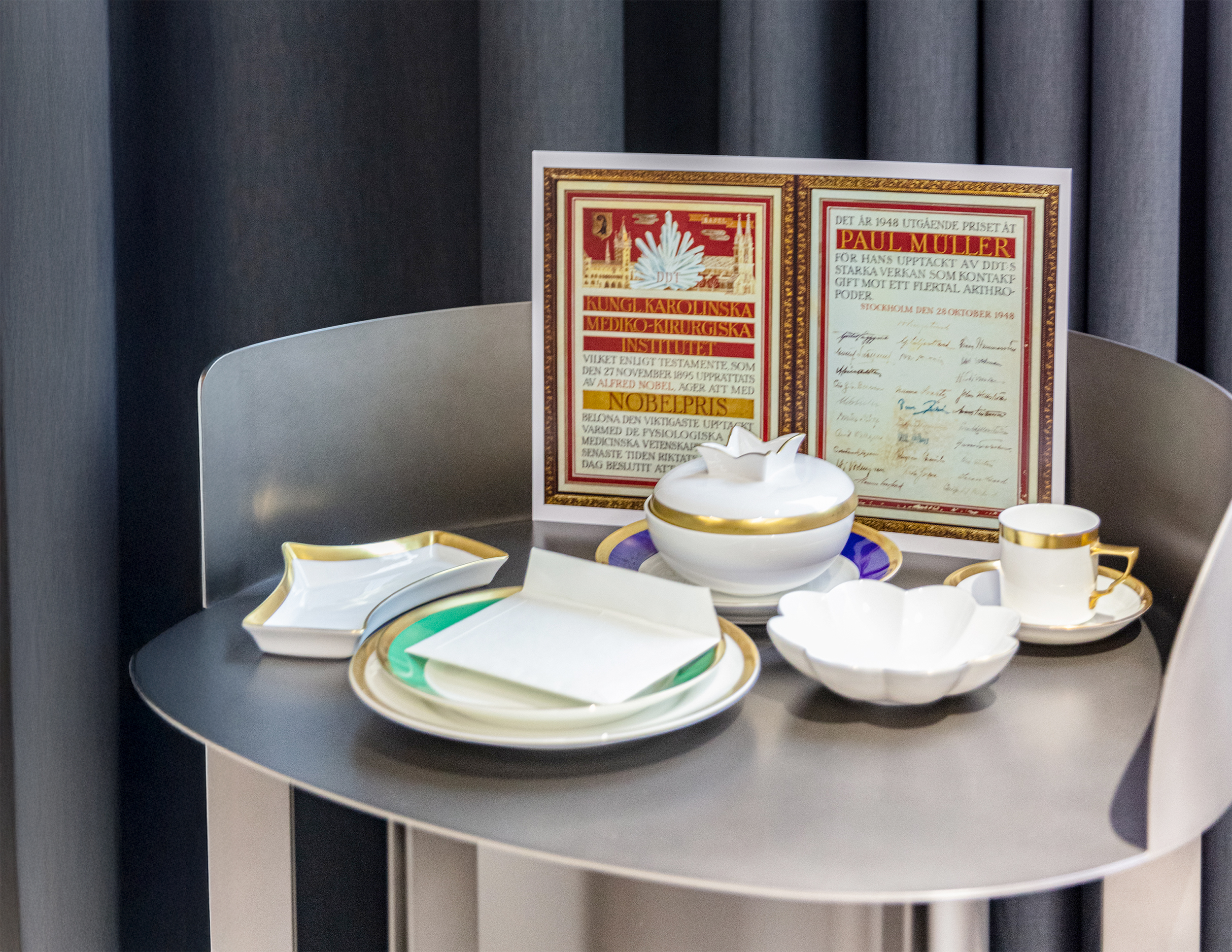 Nobelpreis-Urkunde und Teeservice in der Ausstellung.