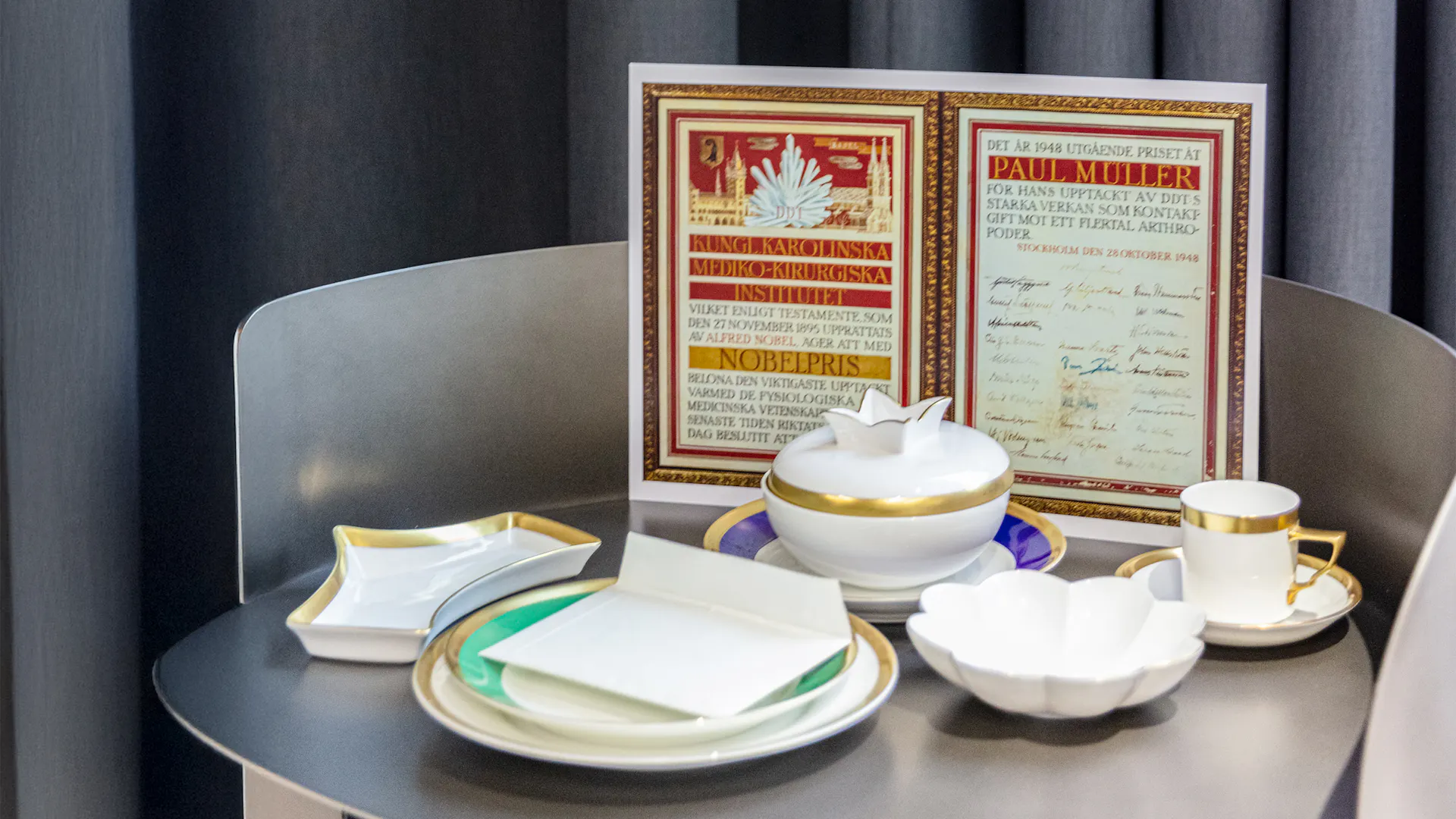 Nobelpreis-Urkunde und Teeservice in der Ausstellung.