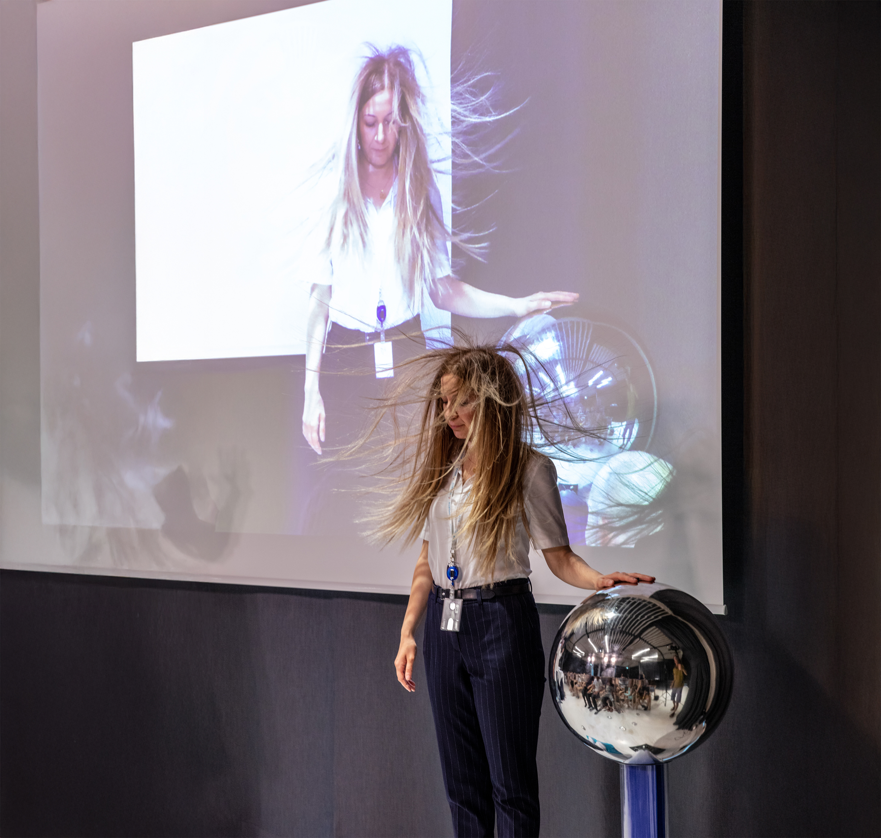 Besucherin beim Van-de-Graaff-Generator: Haare stehen während der Museumsnacht im Novartis Pavillon.