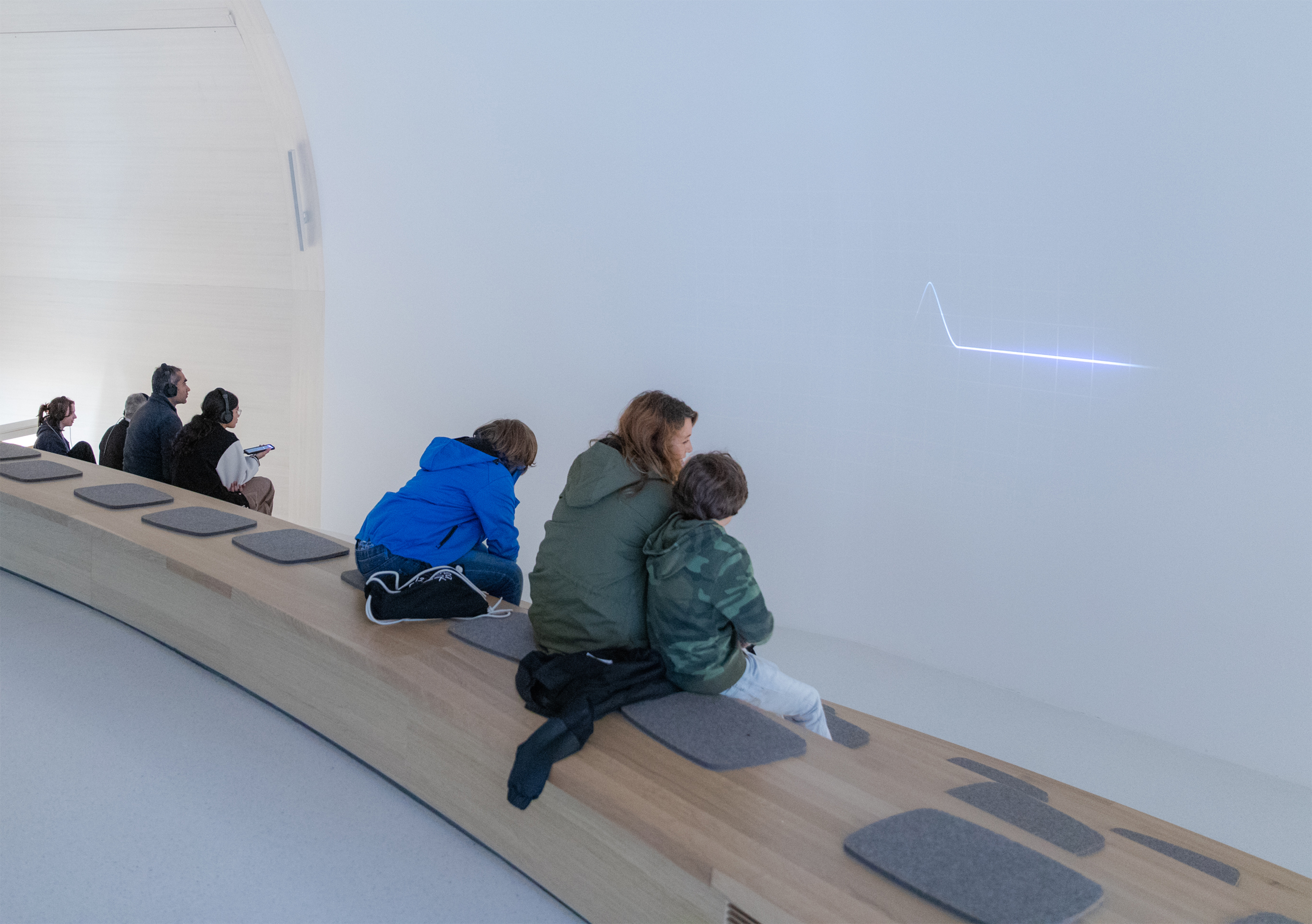 Mutter und Kinder bei der Museumsnacht im Novartis Pavillon vor einer Videoinstallation.