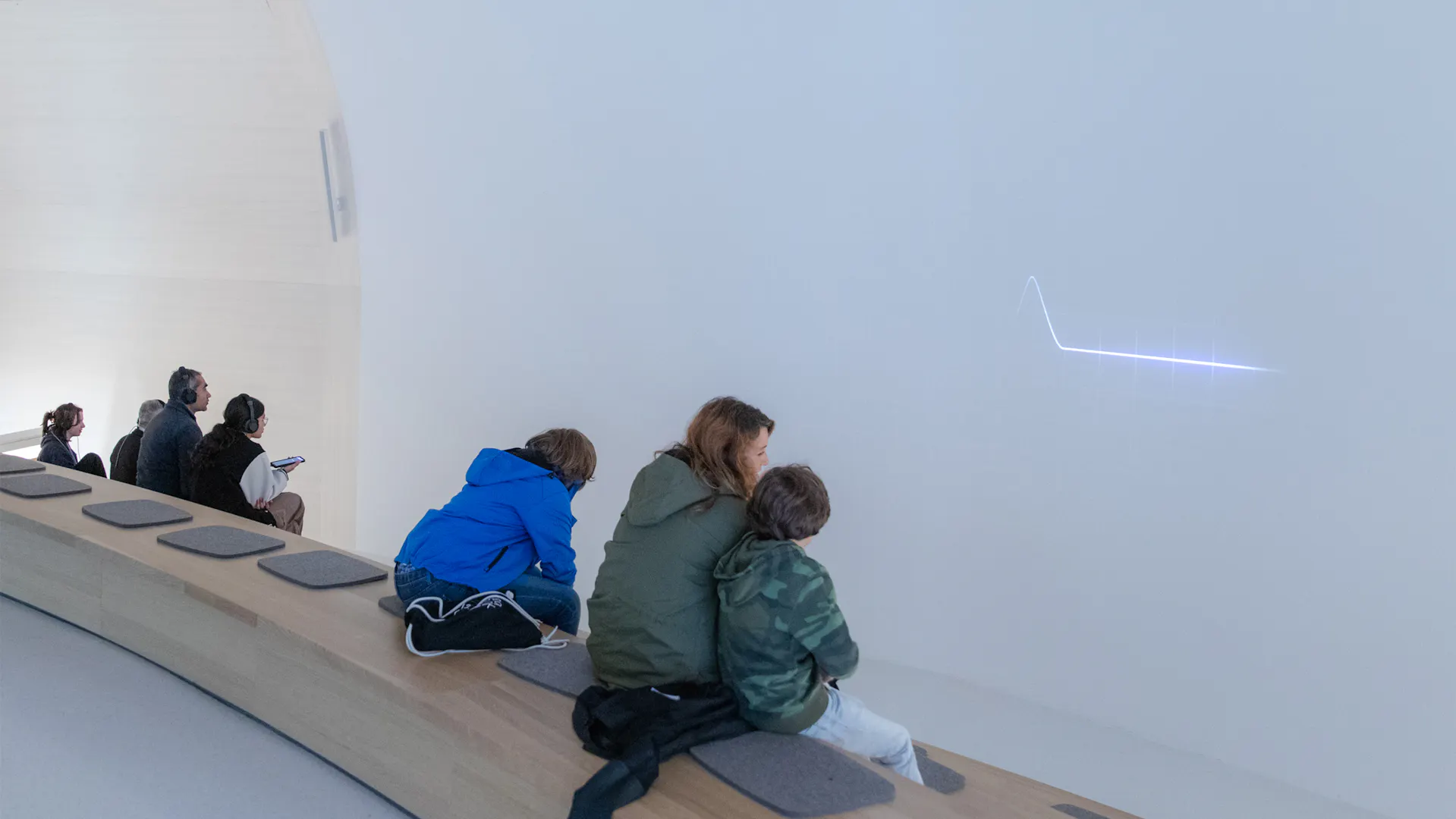 Mutter und Kinder bei der Museumsnacht im Novartis Pavillon vor einer Videoinstallation.
