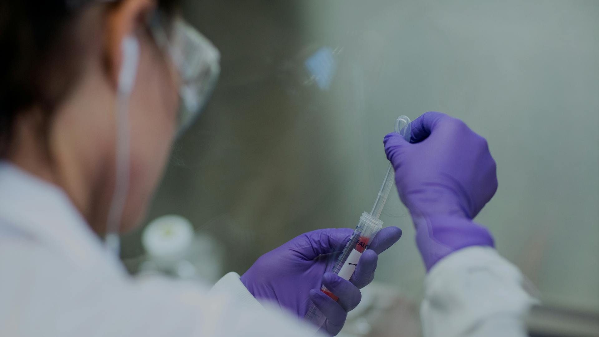 Wissenschaftlerin testet Blutprobe im Reagensglas.