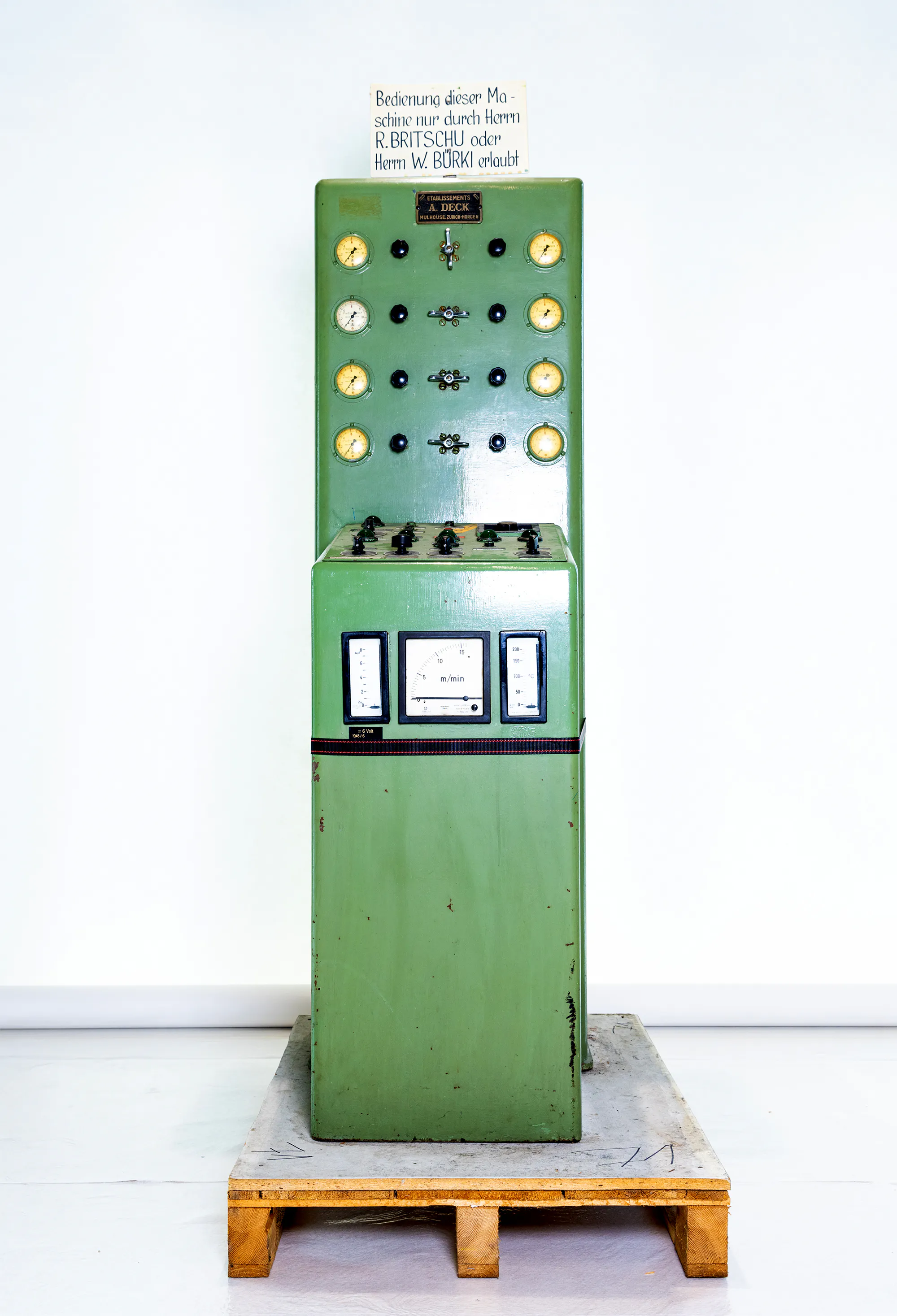 Grünes vertikales Kontrollpanel mit Druckmessern, Kontrollleuchten und Schaltern – Industriebedienfeld.