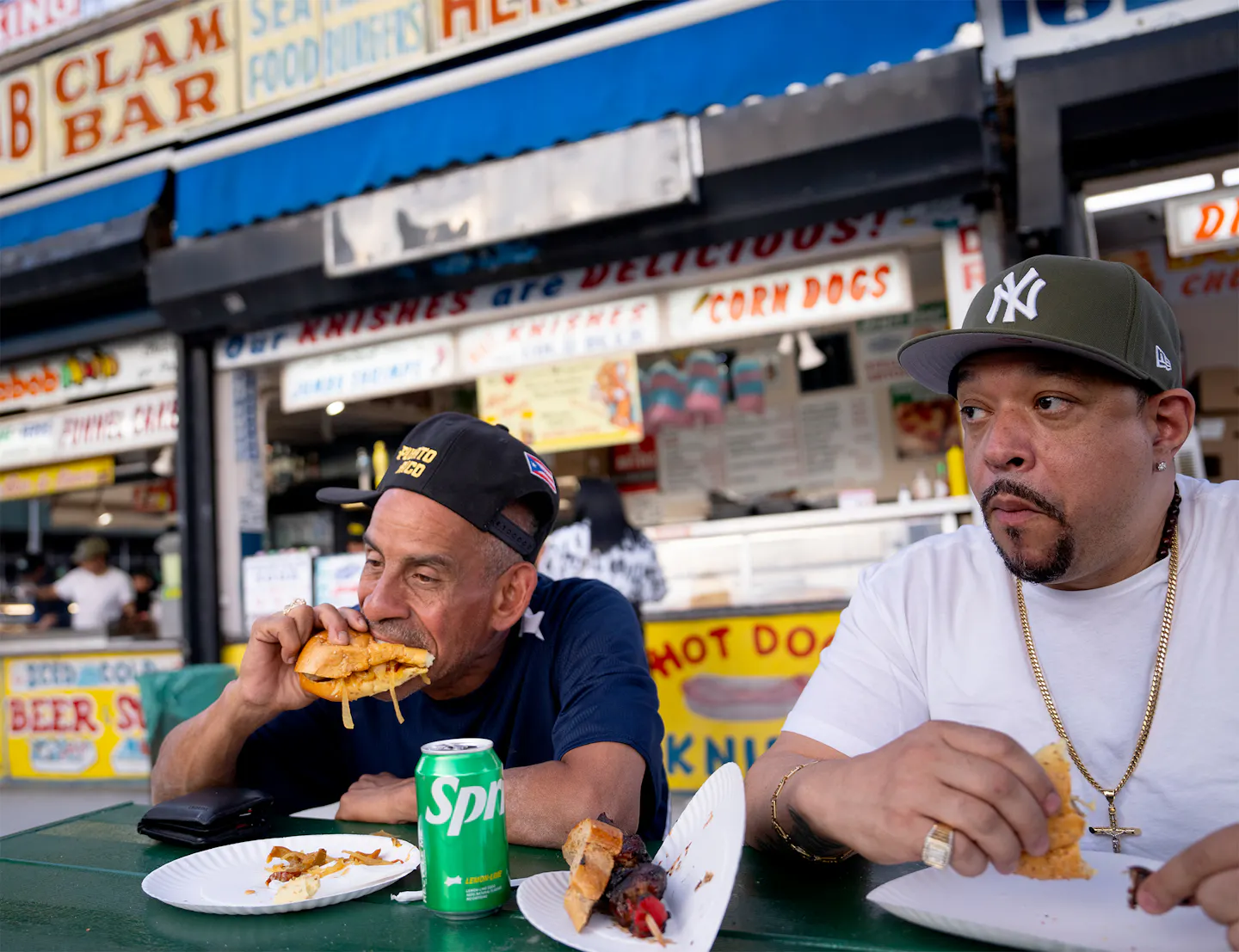 Zwei New Yorker essen Burger an einem Imbissstand.