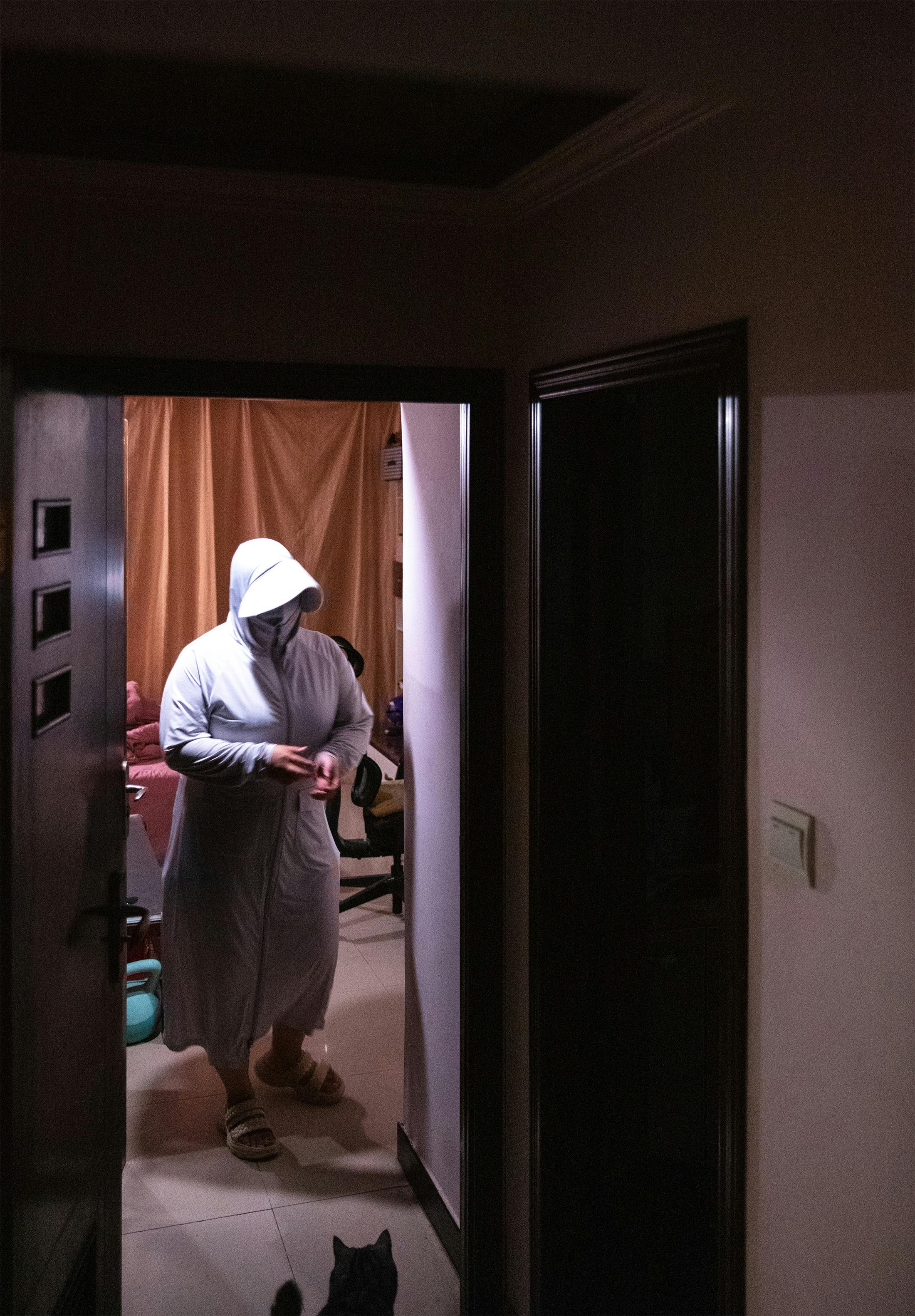 Jiahui Zhang trägt Maske und Ganzkörper-Schutzanzug.