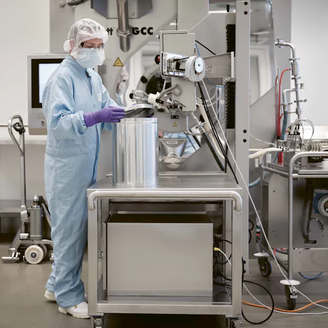 Film-coated tablets are packed into bins prior to final packaging on packaging lines.