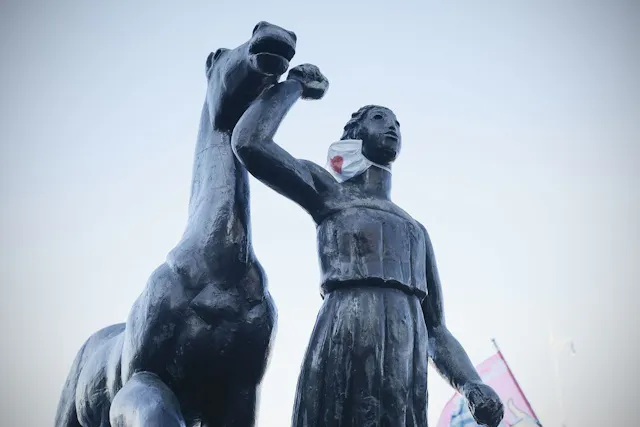 Female statue with mask.