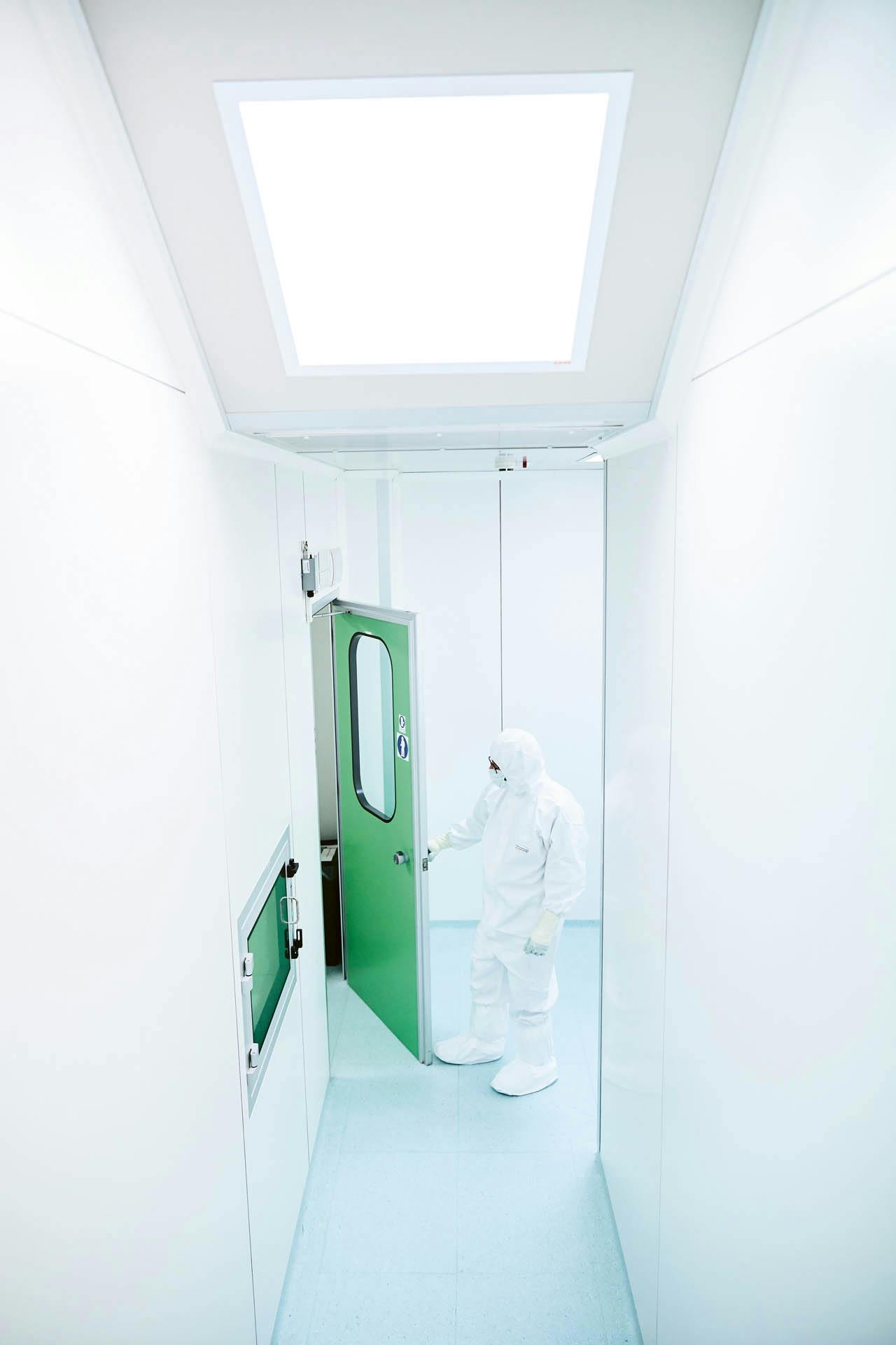 Employee enters the laboratory of the company Advanced Accelerator Applications in a protective suit.