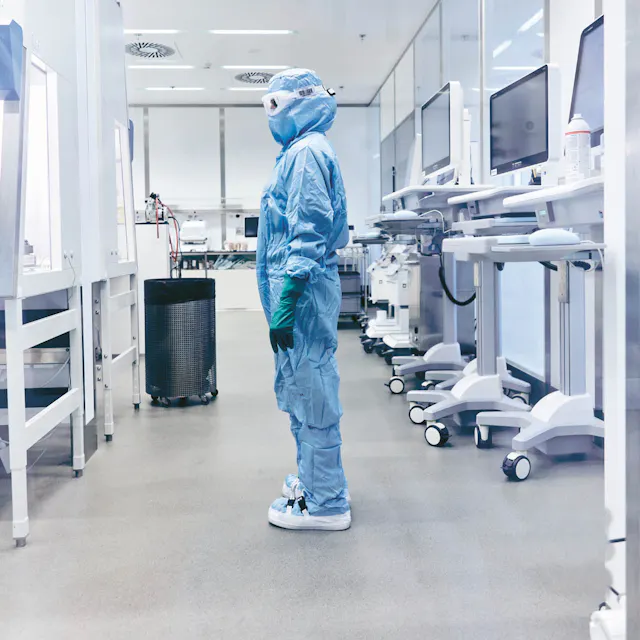 An associate is standing in front of a biosafety cabinet