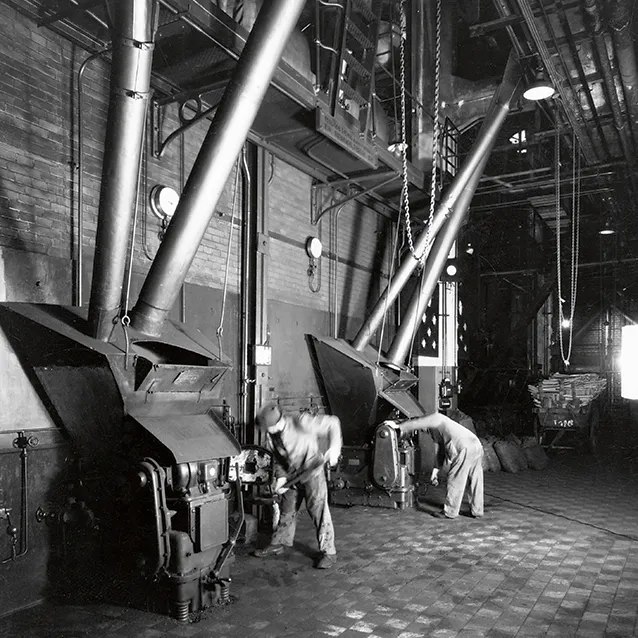 Workers heat the steam boiler with coal.