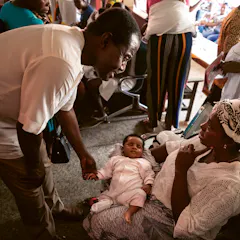 Dr. Kwaku Ohene-Frempong examining a baby in a doctor's office practice in Ghana.