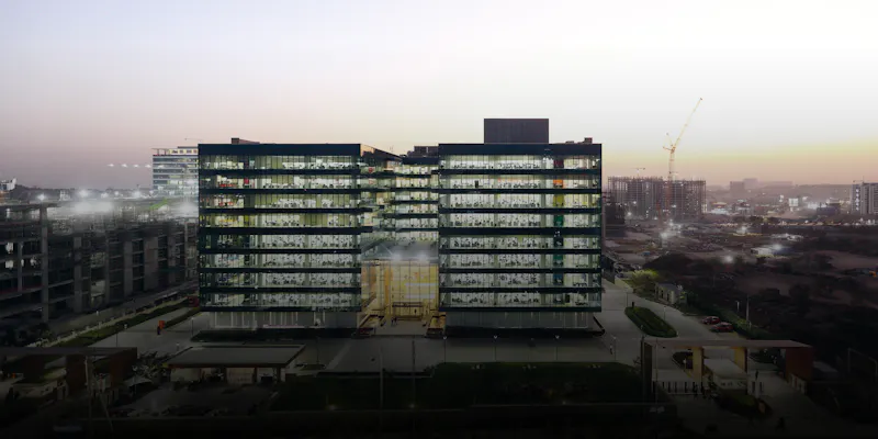Ein in den Regenbogenfarben leuchtender Kristall bei Nacht: die Novartis Knowledge City in Hyderabad.