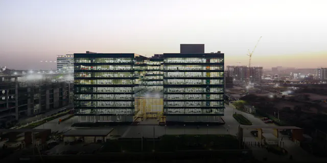Ein in den Regenbogenfarben leuchtender Kristall bei Nacht: die Novartis Knowledge City in Hyderabad.