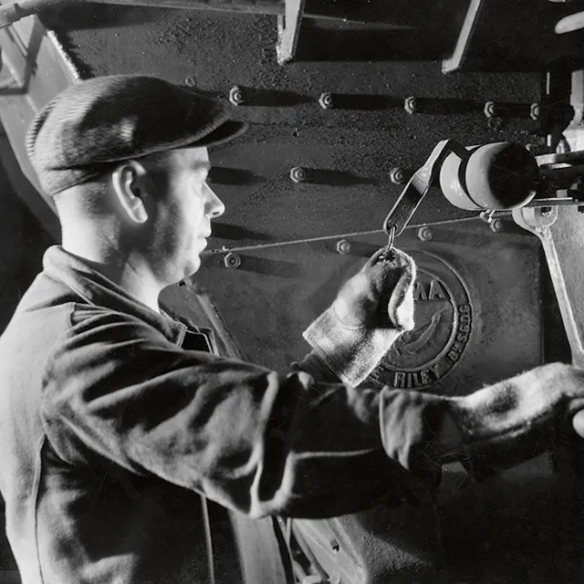 A worker checks the fire in the steam boiler.
