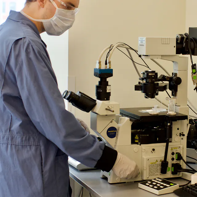 Gianluca Etienne brings hundreds of droplets into focus on a microscope in the MiC-Drop lab in Cambridge.