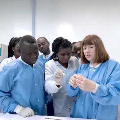 Patti White explains the functions of the Hemex diagnostic device to team colleagues in the laboratory.