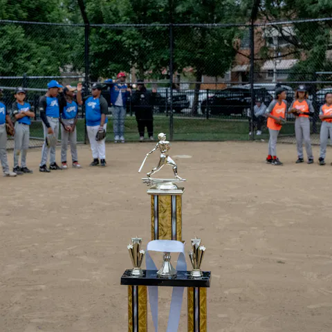 Baseball Cup standing in front of two youth baseball teams.