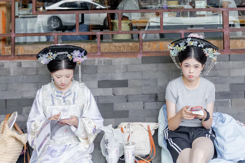 Girls in Beijing with traditional headpiece and whitening make-up.