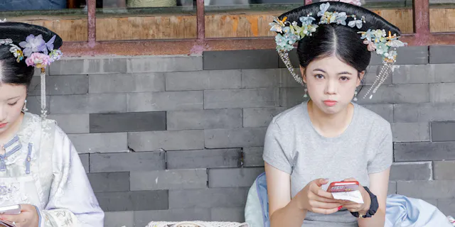 Girls in Beijing with traditional headpiece and whitening make-up.