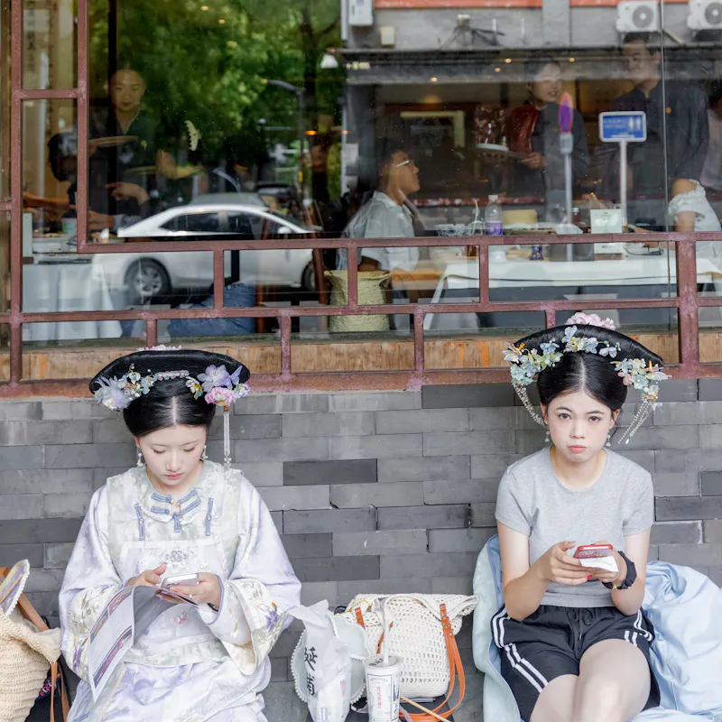 Girls in Beijing with traditional headpiece and whitening make-up.