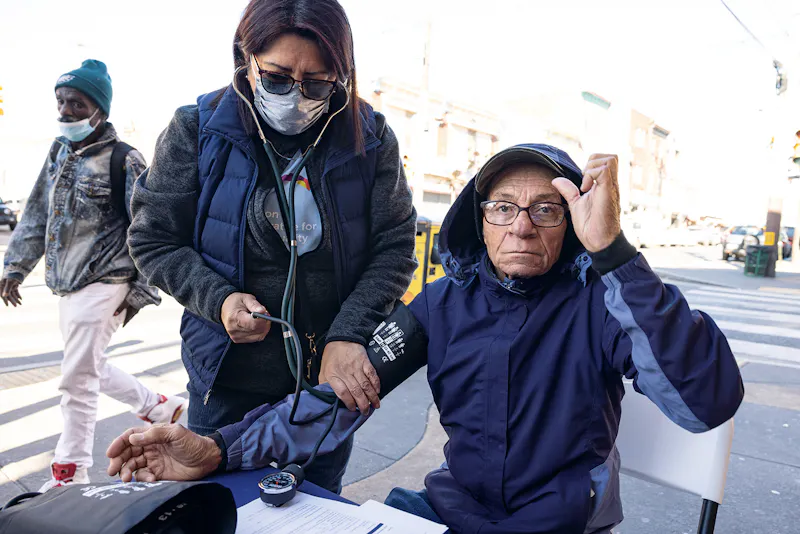 Nancy Porroa (links), eine in Peru geborene und 2002 nach Philadelphia eingewanderte Gesundheitshelferin der Jefferson Community, überprüft den Blutdruck eines Anwohners.  Nancy und ihre Kollegen von der Jefferson Collaborative for Health Equity sagen, dass sie sich durch ihre Arbeit belohnt fühlen, mit der sie seit langem bestehende soziale Barrieren beseitigen und Komplikationen durch vermeidbare Krankheiten in den Gemeinden, in denen sie leben, verringern.