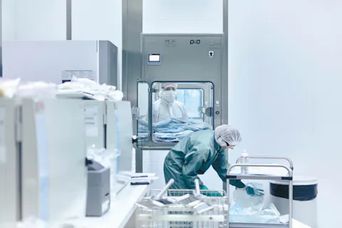 An employee of the cell and gene production in Stein prepares material for the production zone in a protective suit. 