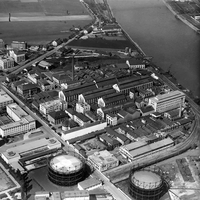 Während vieler Jahrzehnte waren die Produktionsanlagen prägend für das Werk  St.Johann, wie dieses Luftbild von 1946 beweist. Am linken Bildrand erkennt man das heutige Forum 1, das später zu einem Rechteck mit Innenhof ergänzt wurde.