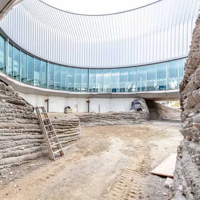 Die während der Bauphase noch grauen Wände des Hohlwegs unter dem Pavillon werden bereits im Frühling mit frischem Grün bedeckt sein.