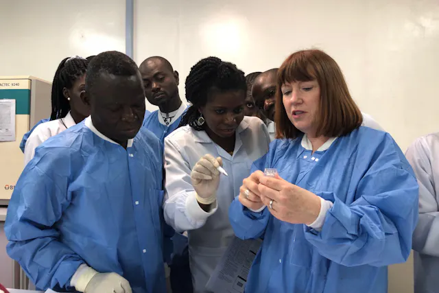 Patti White explains the functions of the Hemex diagnostic device to team colleagues in the laboratory.