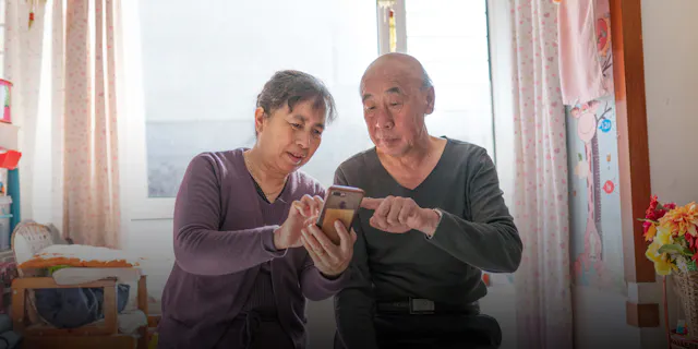 Jian Zhang and his wife check the AI Nurse app at home in Shenyang, China. Mr. Zhang is one of approximately 300 000 people in China using the AI Nurse digital health app.