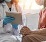 A doctor discusses items on a tablet with a patient.