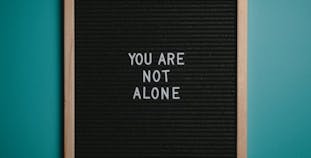 A board featuring the words "You are not alone" on it. 