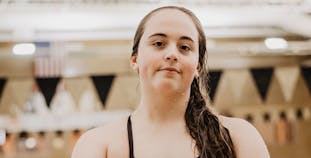Teenager Lena Oslund stands in front of a pool and poses.