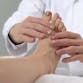 Doctor in lab coat checking patient's foot.