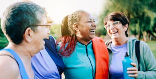 Senior women having fun after exercising outdoors at a park.
