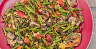 A red plate of tomatoes, mushrooms and green beans.