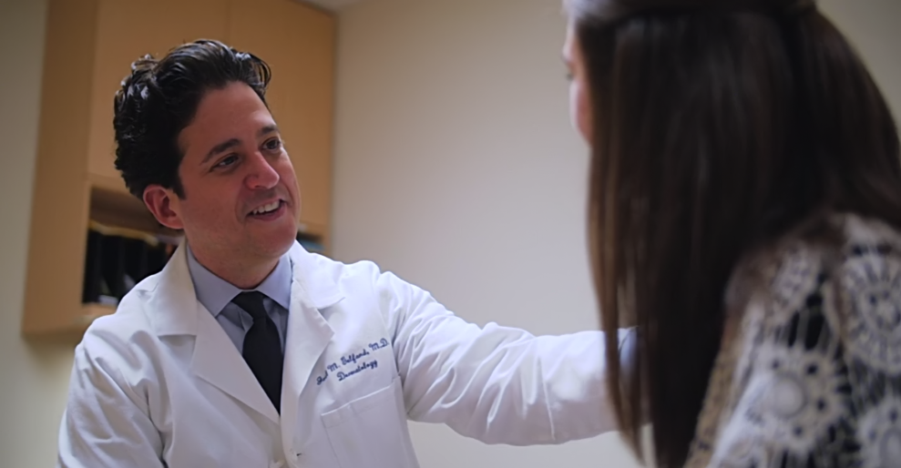 Doctor smiling as he talks with patient