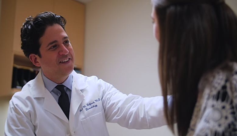 Doctor smiling as he talks with patient