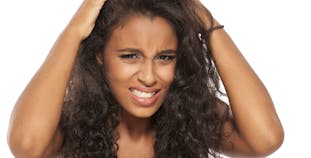 Young dark skinned girl scratching her hair and scalp