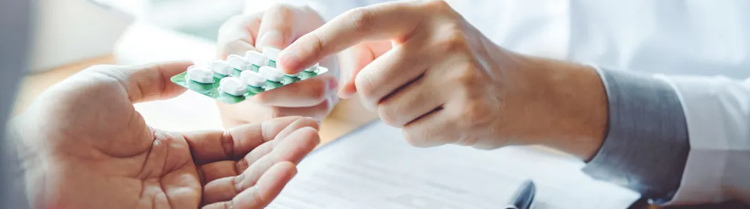 A doctor shows a patient medication in a professional office.