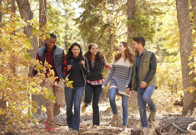 A group of friends hiking in the woods in Autumn.