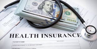 Health insurance with money and a stethoscope. 