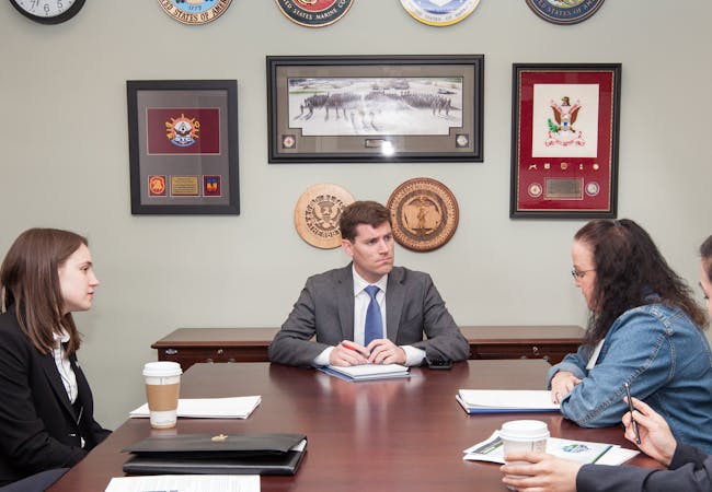 Advocates meet with a politician in an office.