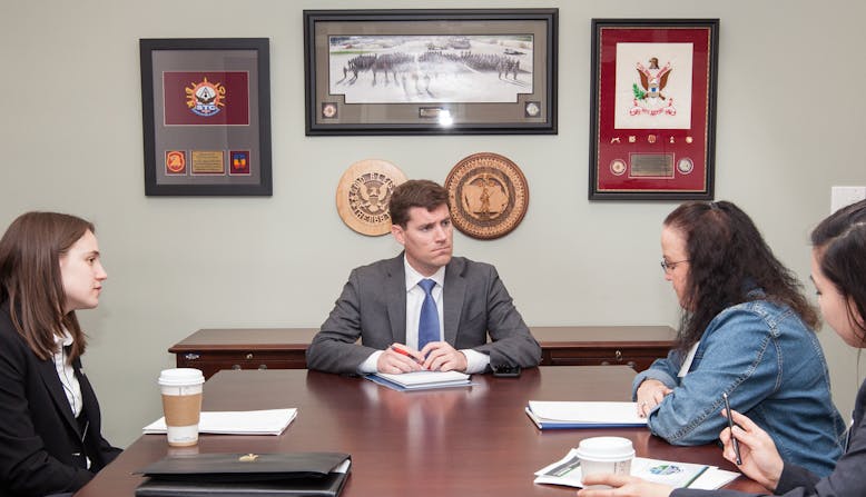 Advocates meet with a politician in an office.