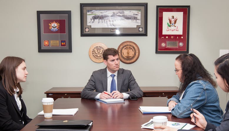 Advocates meet with a politician in an office.