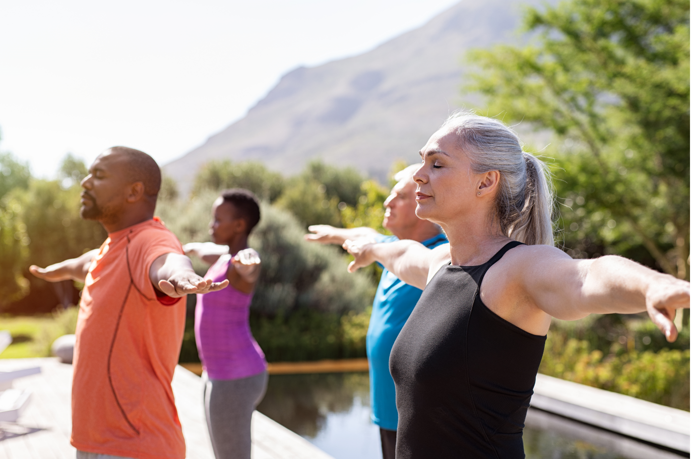 A group of individuals practice yoga outside. 